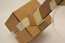Glue cardboard tube to box